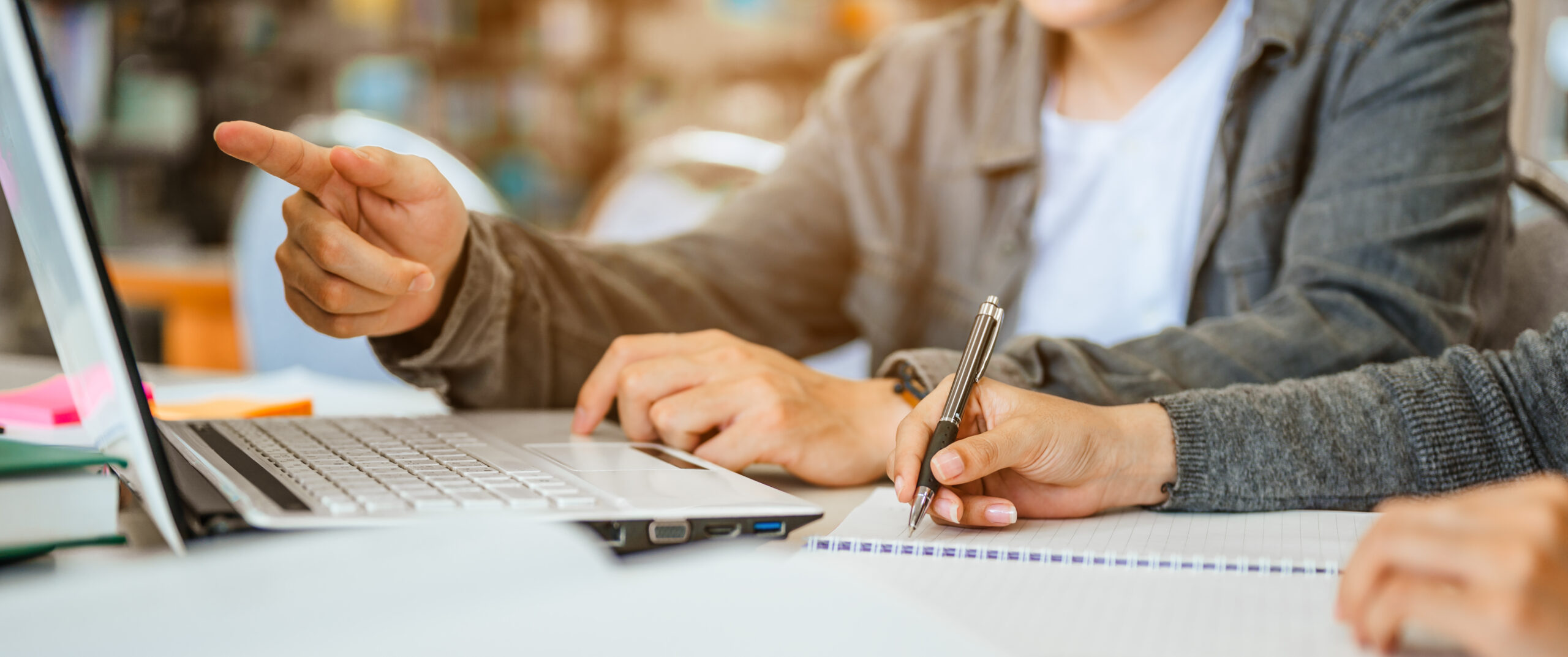 Two students are reading and discussing about exam preparation, presentation, study for test preparation in library.Education, Learning, Student, Campus, University, Lifestyle concept.