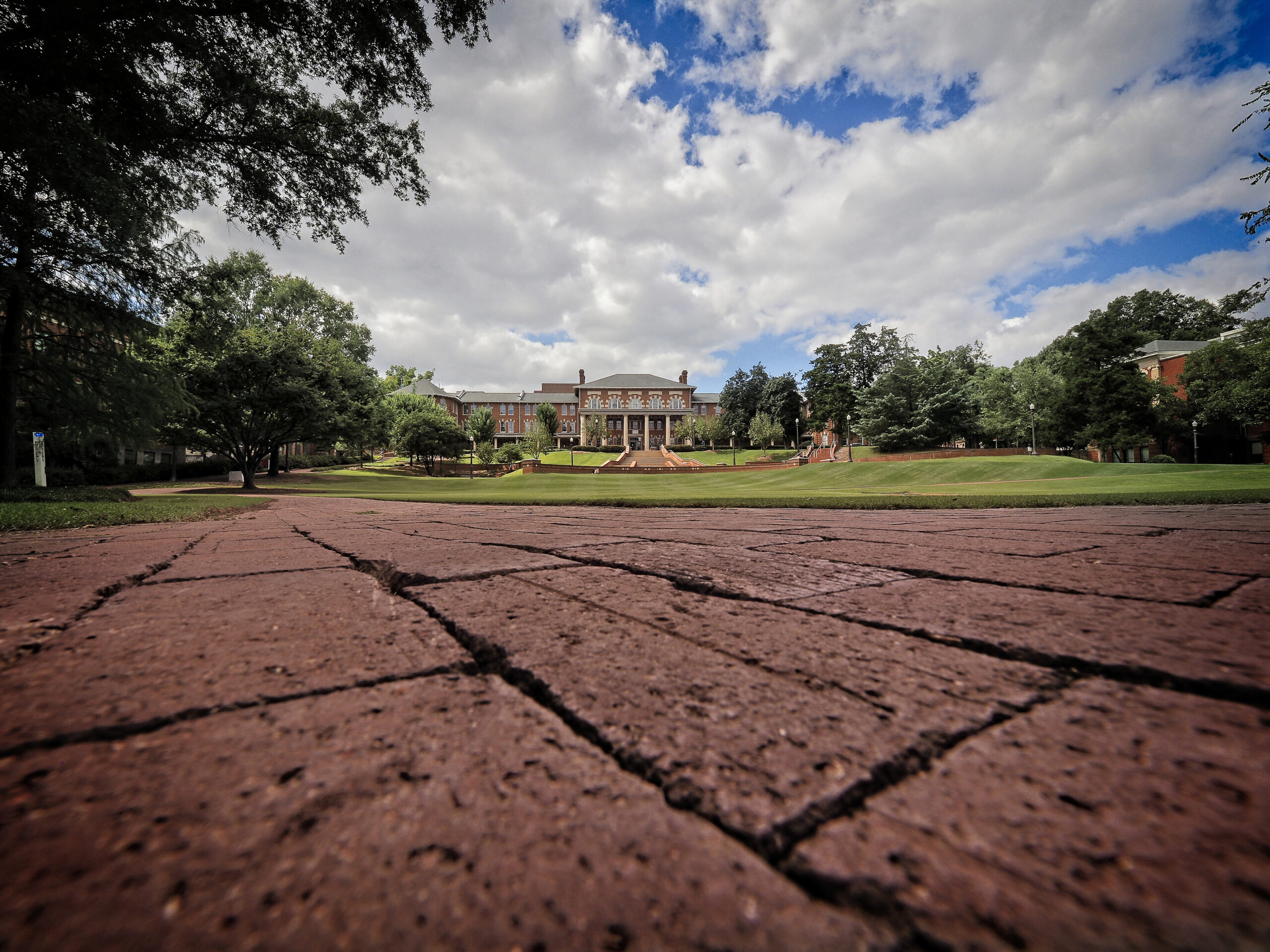 CHASS building at NC&#160;State University, viewed from the Carolina Courtyard with brick pathways, green lawn, and trees.