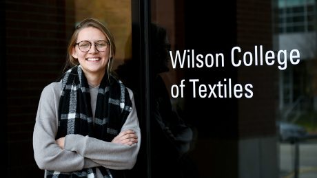 Moriah Mattix in front of a Wilson College of Textiles sign.