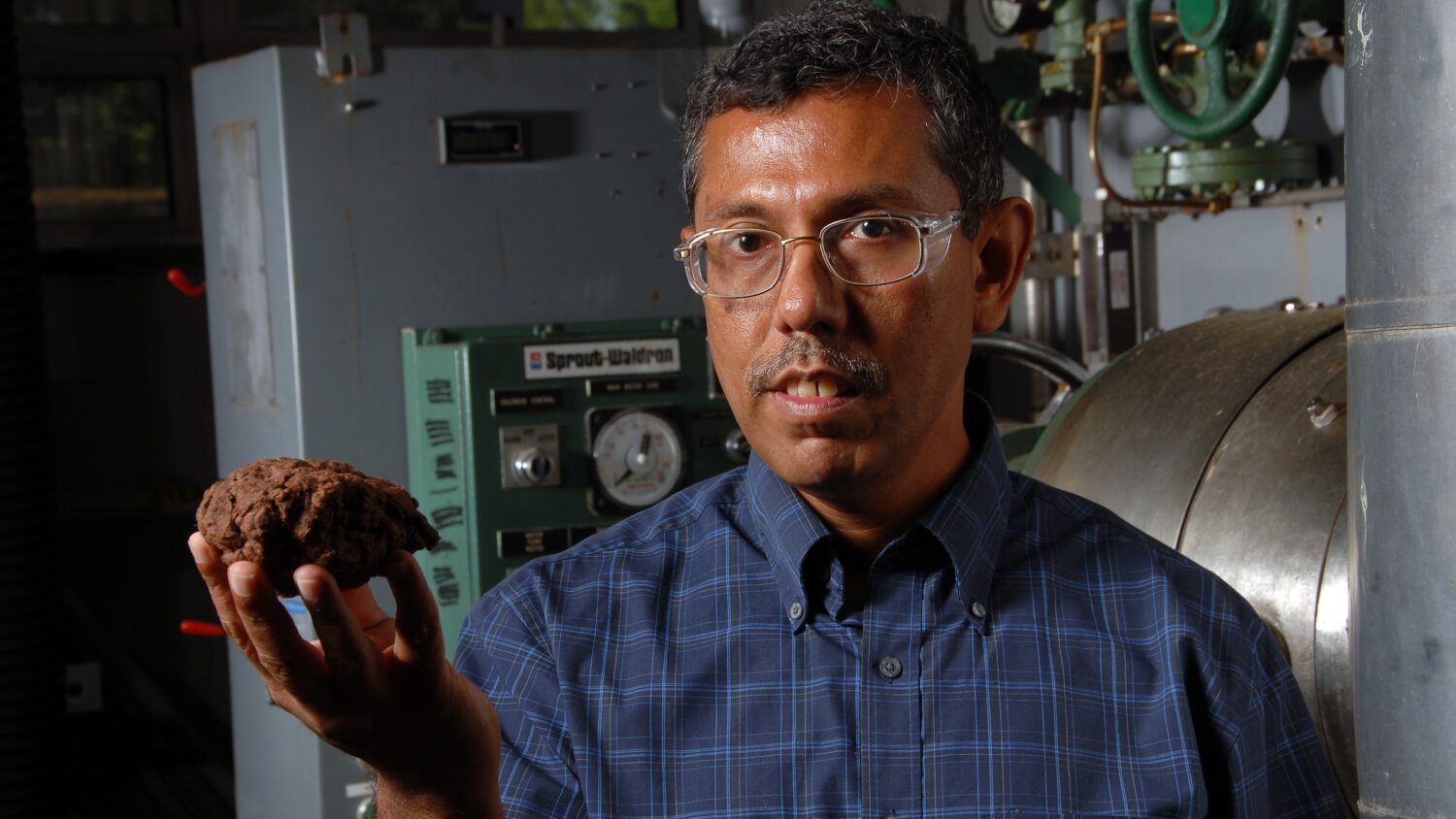 CNR's Hasan Jameel and a lump of woody material pretreated to create fuel.