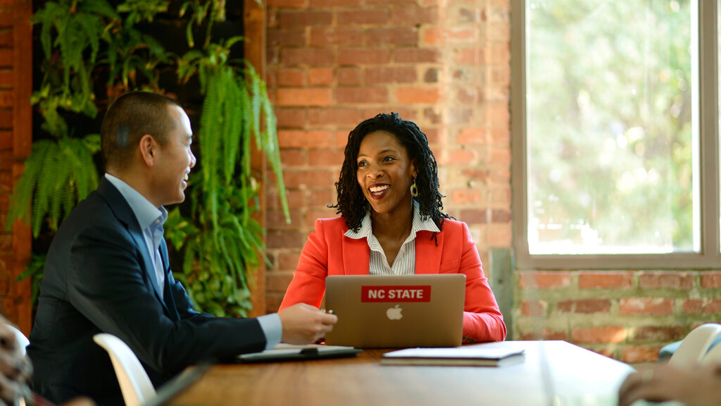 Two people having a discussion at a laptop.