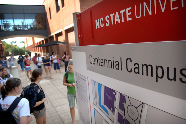 Students standing near a sign that says Centennial Campus.