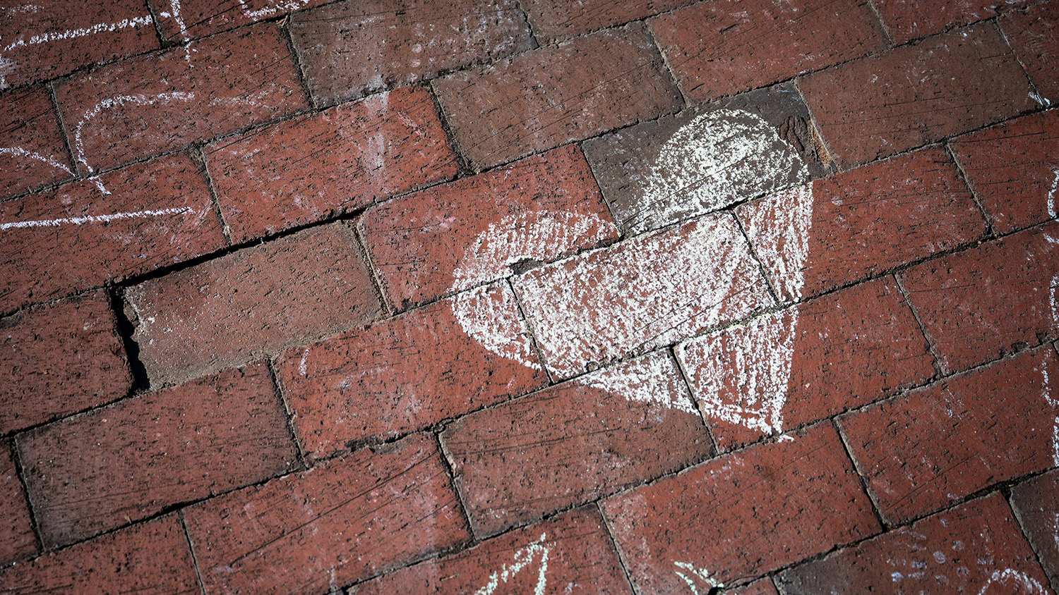 A heart is chalked onto bricks at Wolf Plaza during a wellness event.