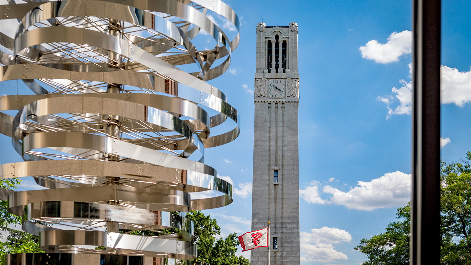NC State's Memorial Belltower stands in front of a clear summer sky on a June afternoon.